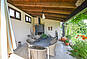 Überdachte Terrasse mit Sitzbereich und Gartenblick