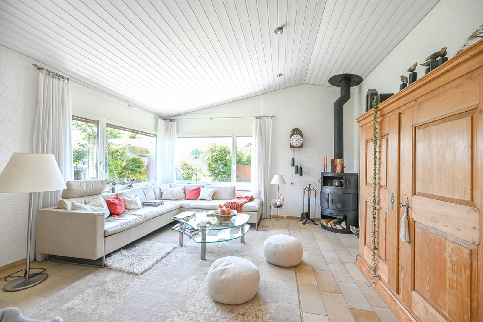 Helles Wohnzimmer mit Kaminofen und Ecksofa