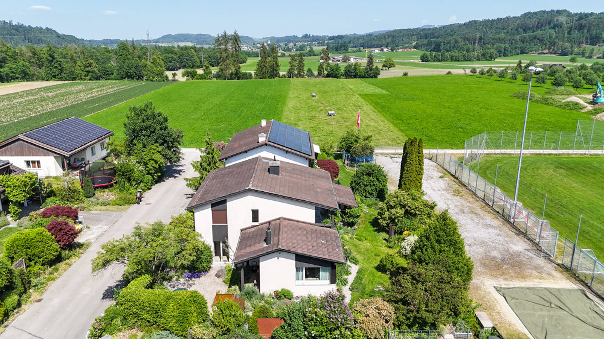 Luftaufnahme eines ländlichen Wohnhauses mit Solardach