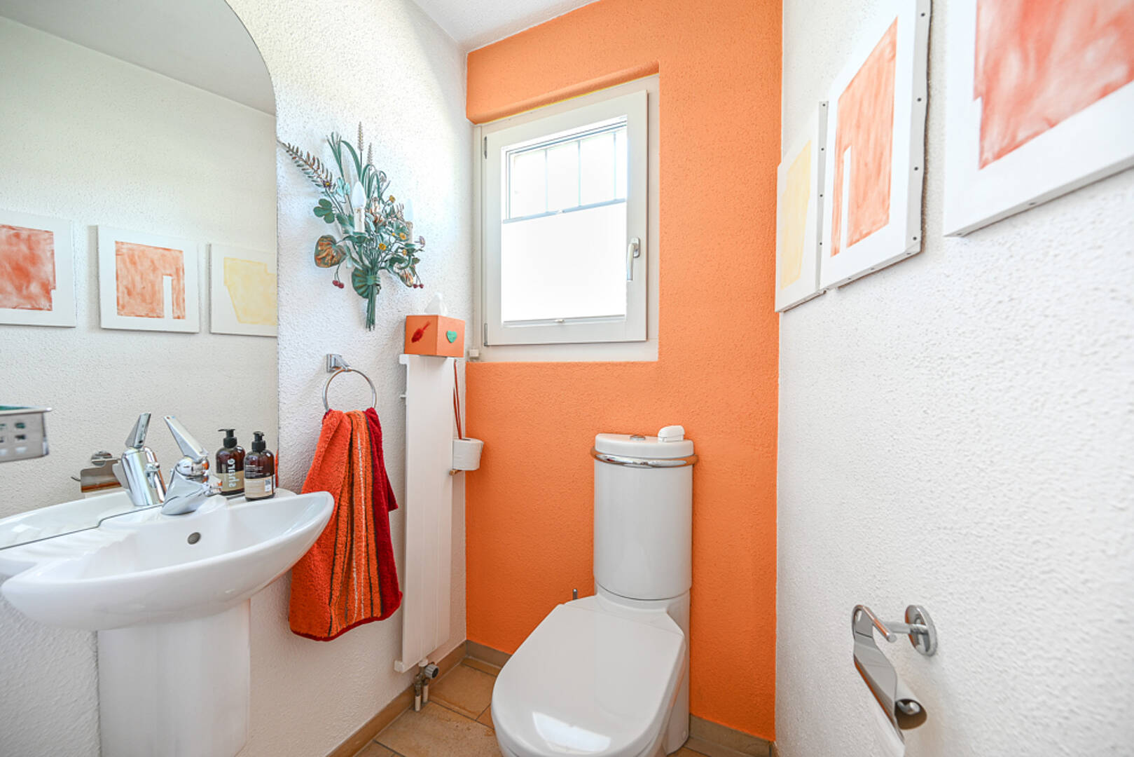 Gäste-WC mit orangefarbener Akzentwand