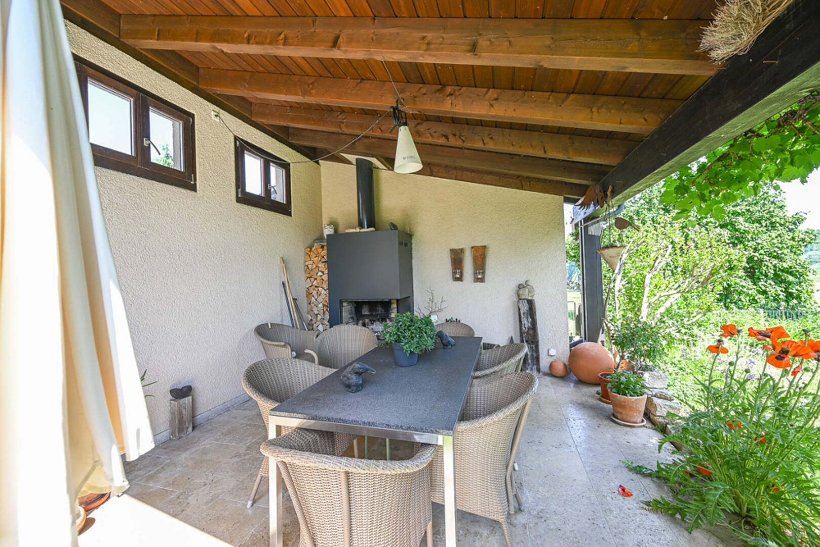 Überdachte Terrasse mit Essbereich und Kamin