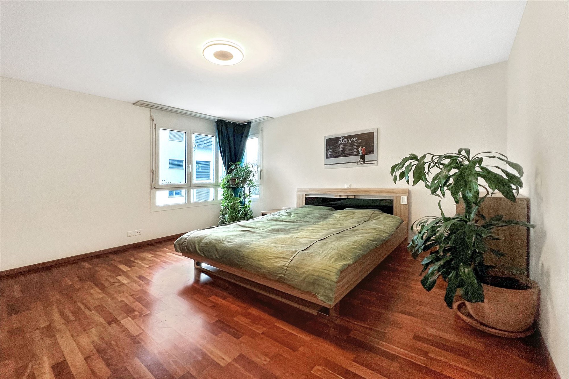 Helles Schlafzimmer mit Holzfußboden und Doppelbett