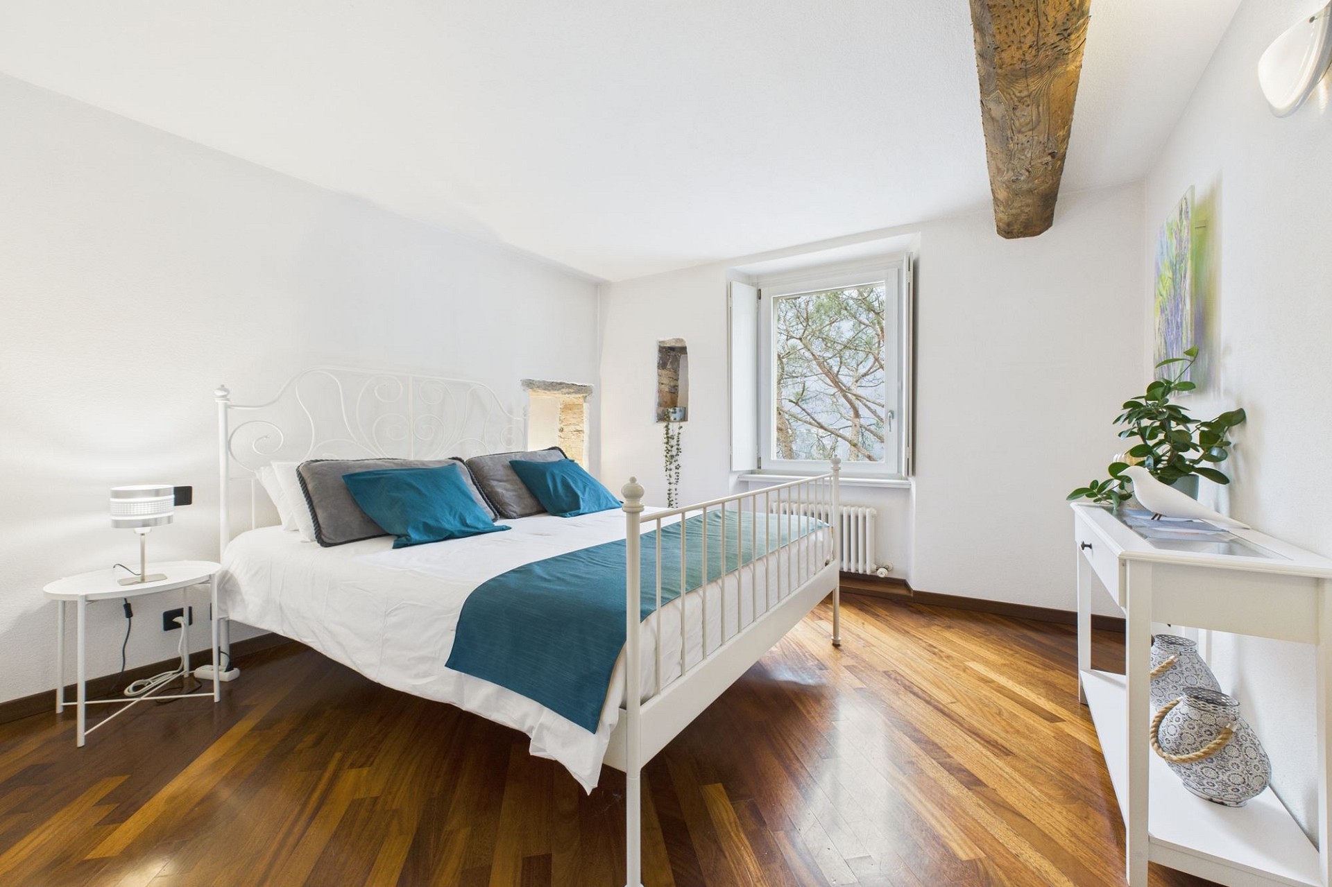 Helles Schlafzimmer mit weißen Möbeln und Holzboden