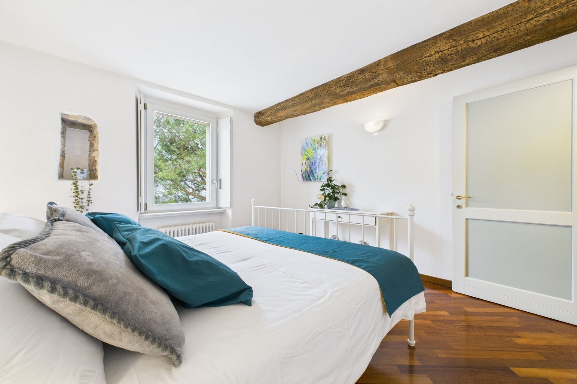 Helles Schlafzimmer mit sichtbaren Holzbalken