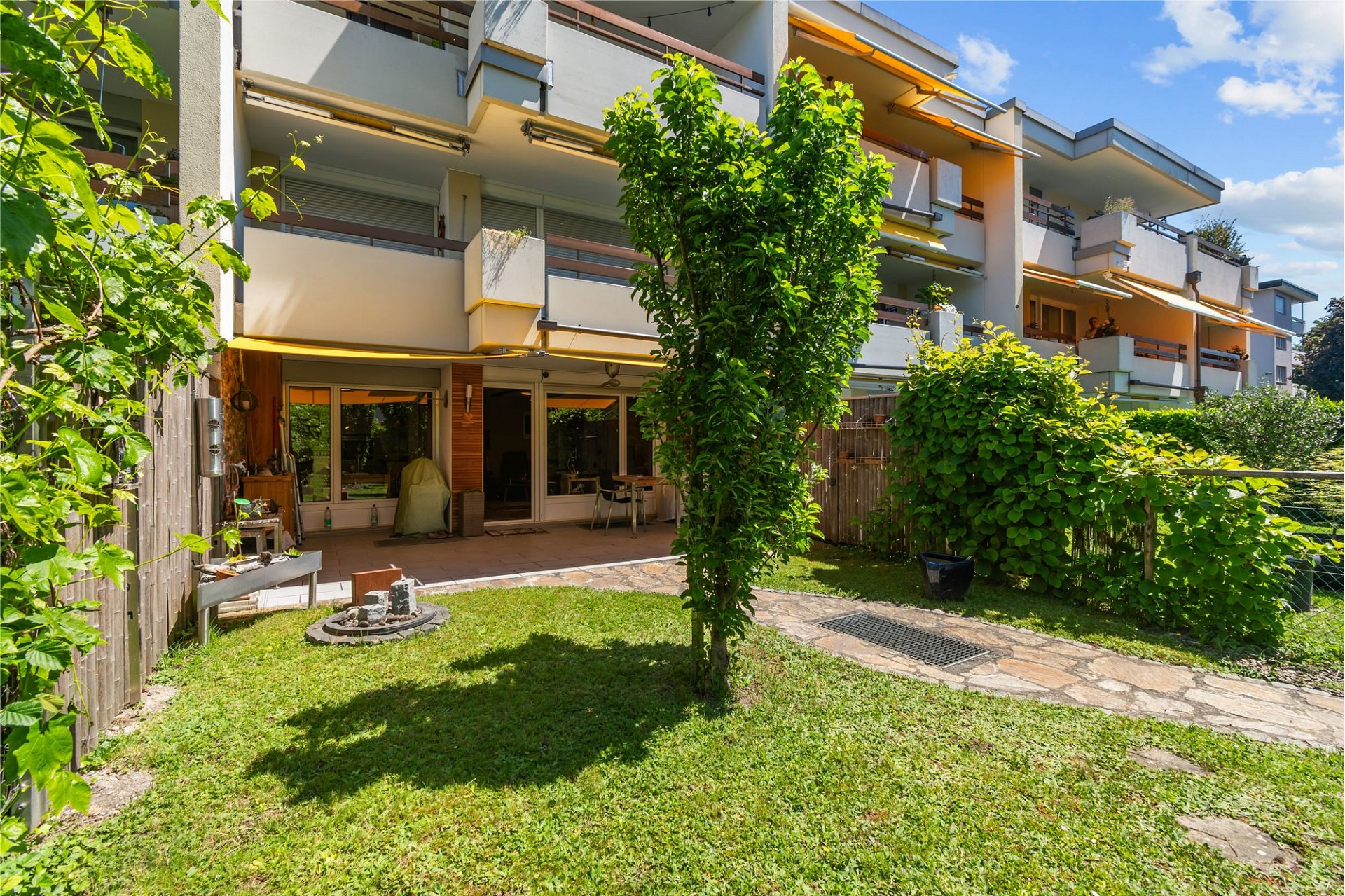 Gartenansicht mit Mehrfamilienhaus und Terrasse