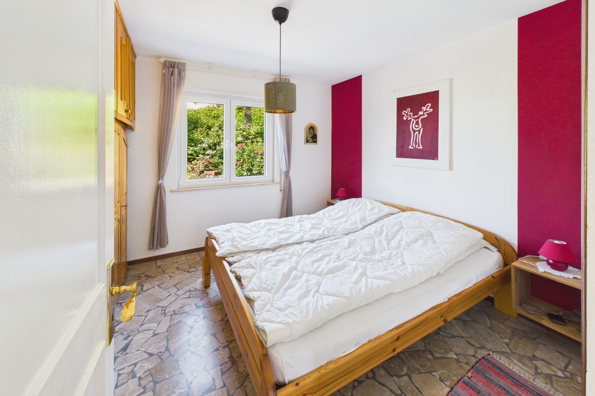 Helles Schlafzimmer mit Bett und Gartenblick