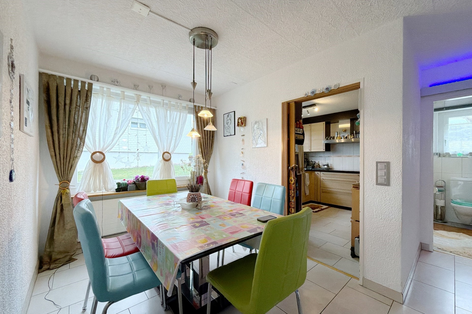 Helles Esszimmer mit Blick in die Küche und ins Bad