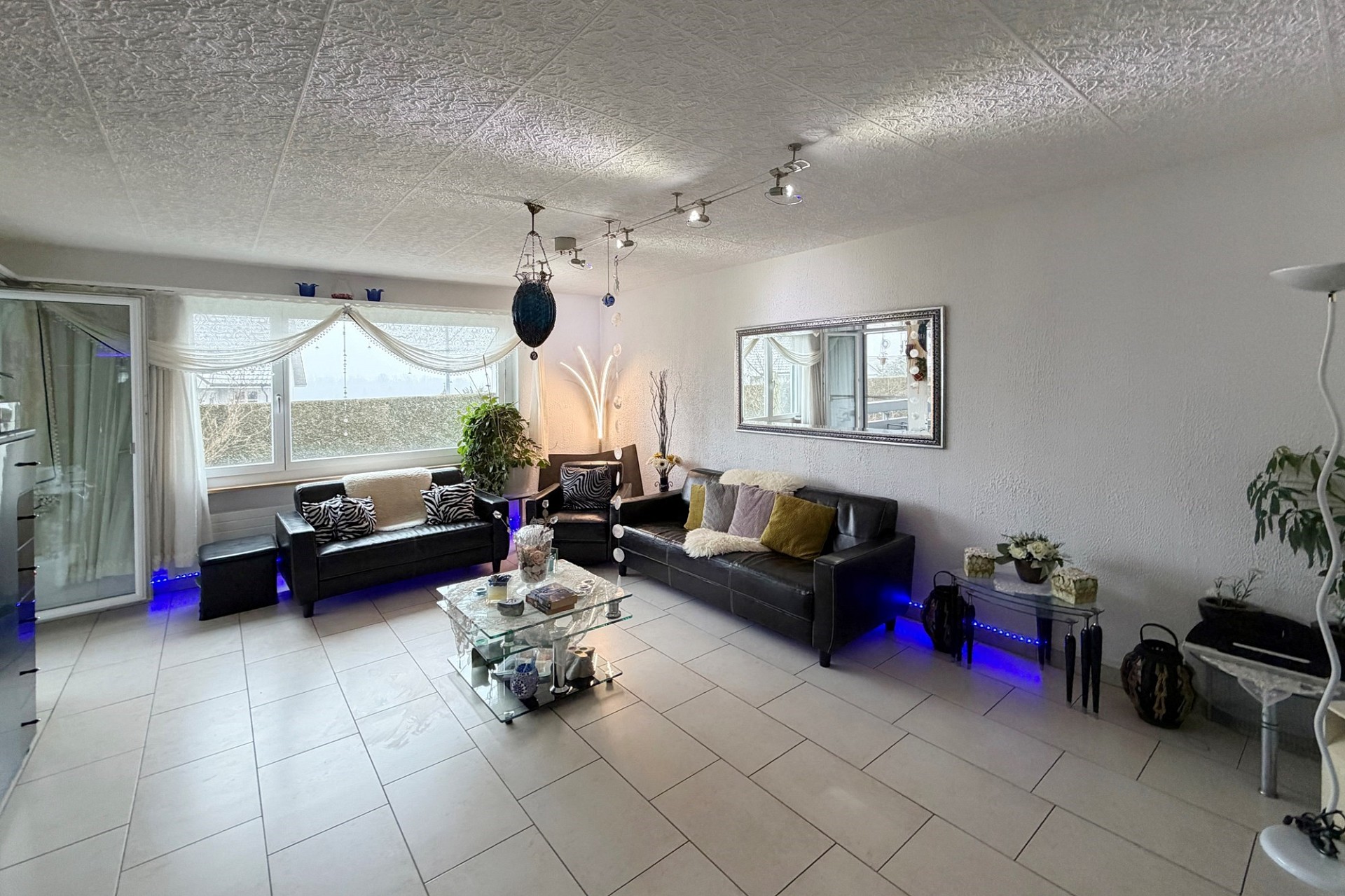 Modern eingerichtetes Wohnzimmer mit großer Fensterfront