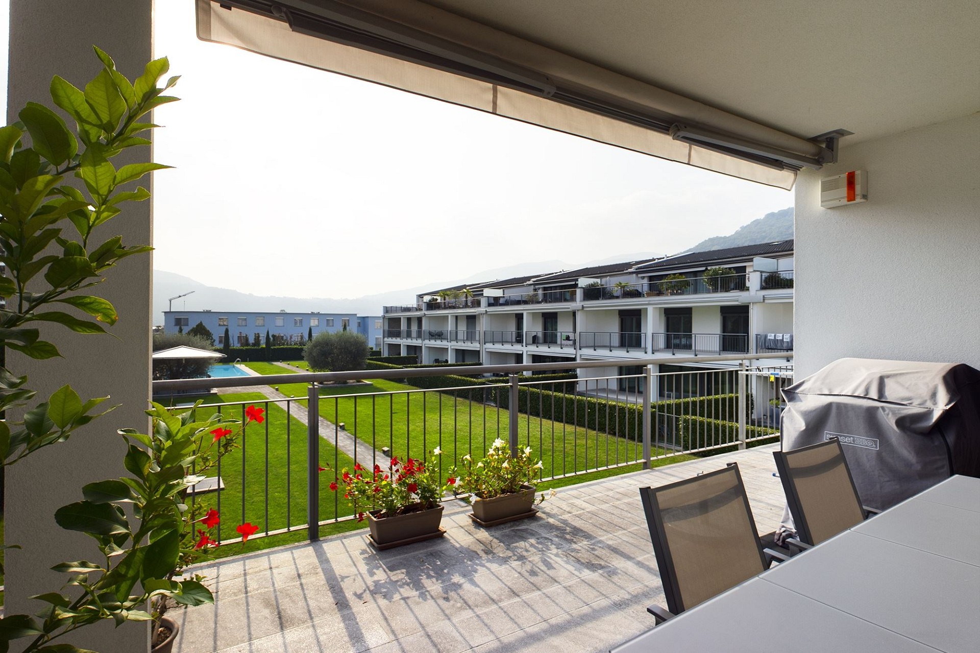 Balkon mit Blick auf Wohnanlage und Bergkulisse
