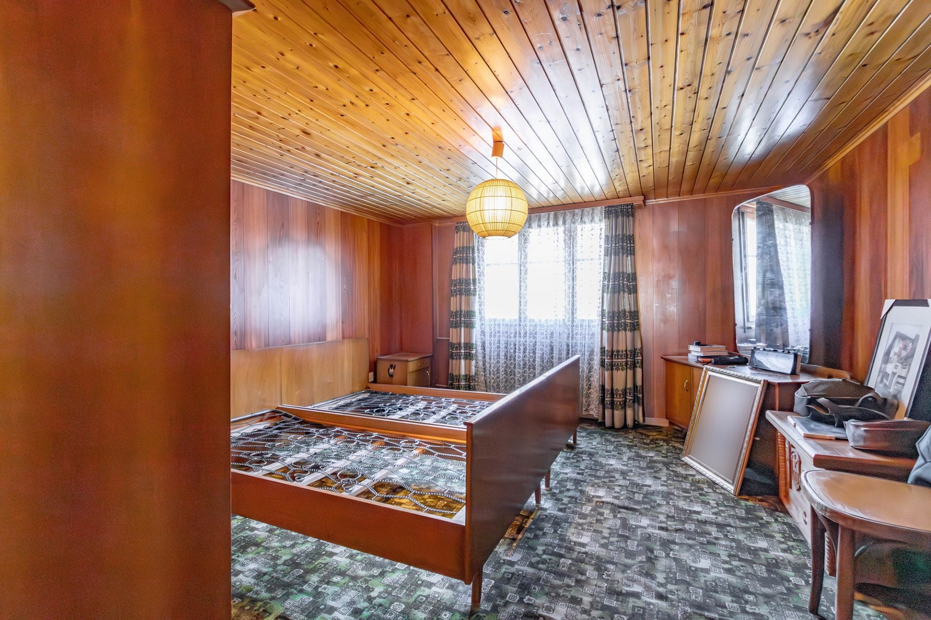 Holzverkleidetes Schlafzimmer mit Retro-Ausstattung