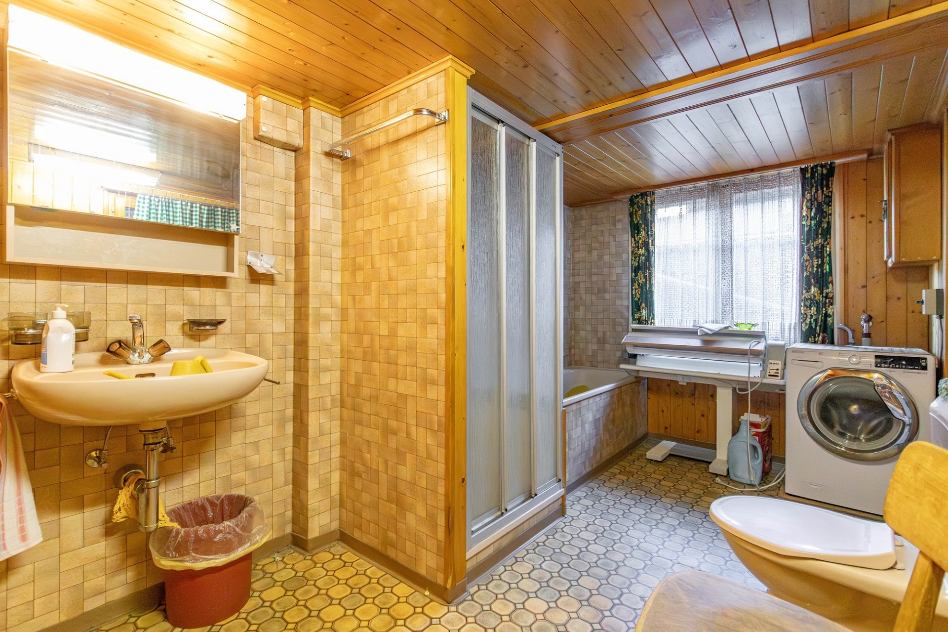 Badezimmer mit Waschtisch, Dusche und Waschmaschine