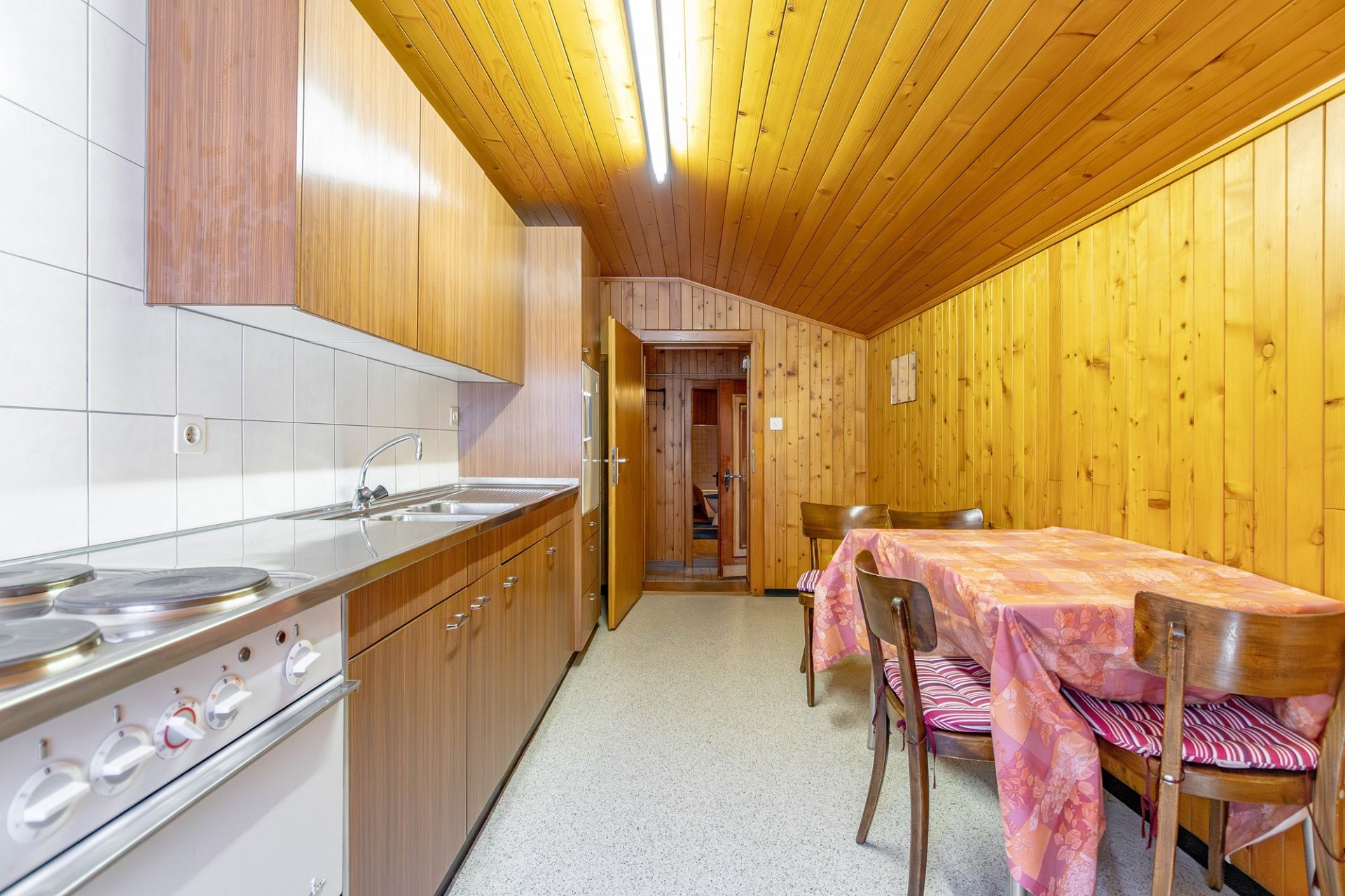 Schmale Wohnküche mit Holzvertäfelung