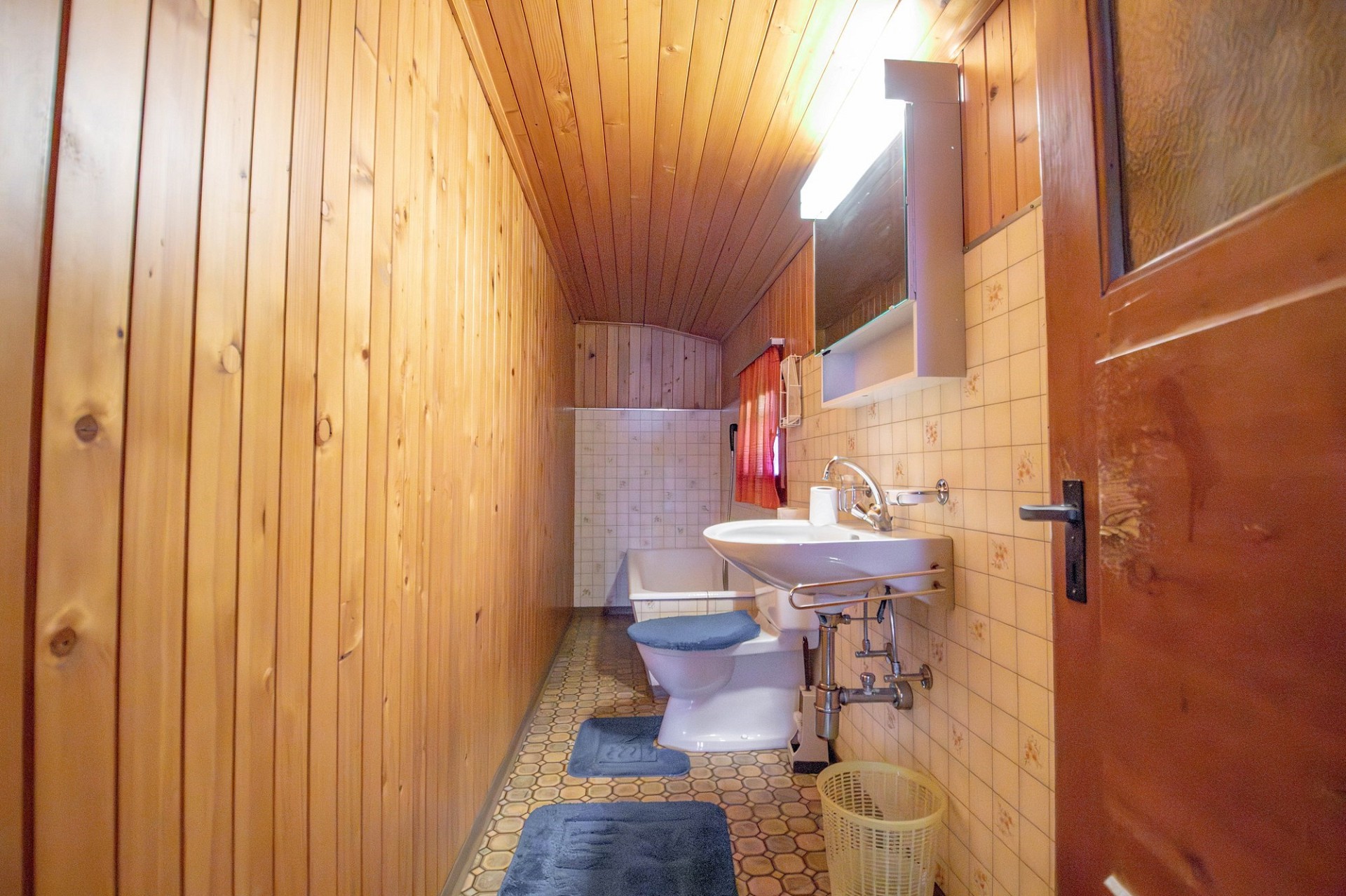 Langes Badezimmer mit Holzvertäfelung