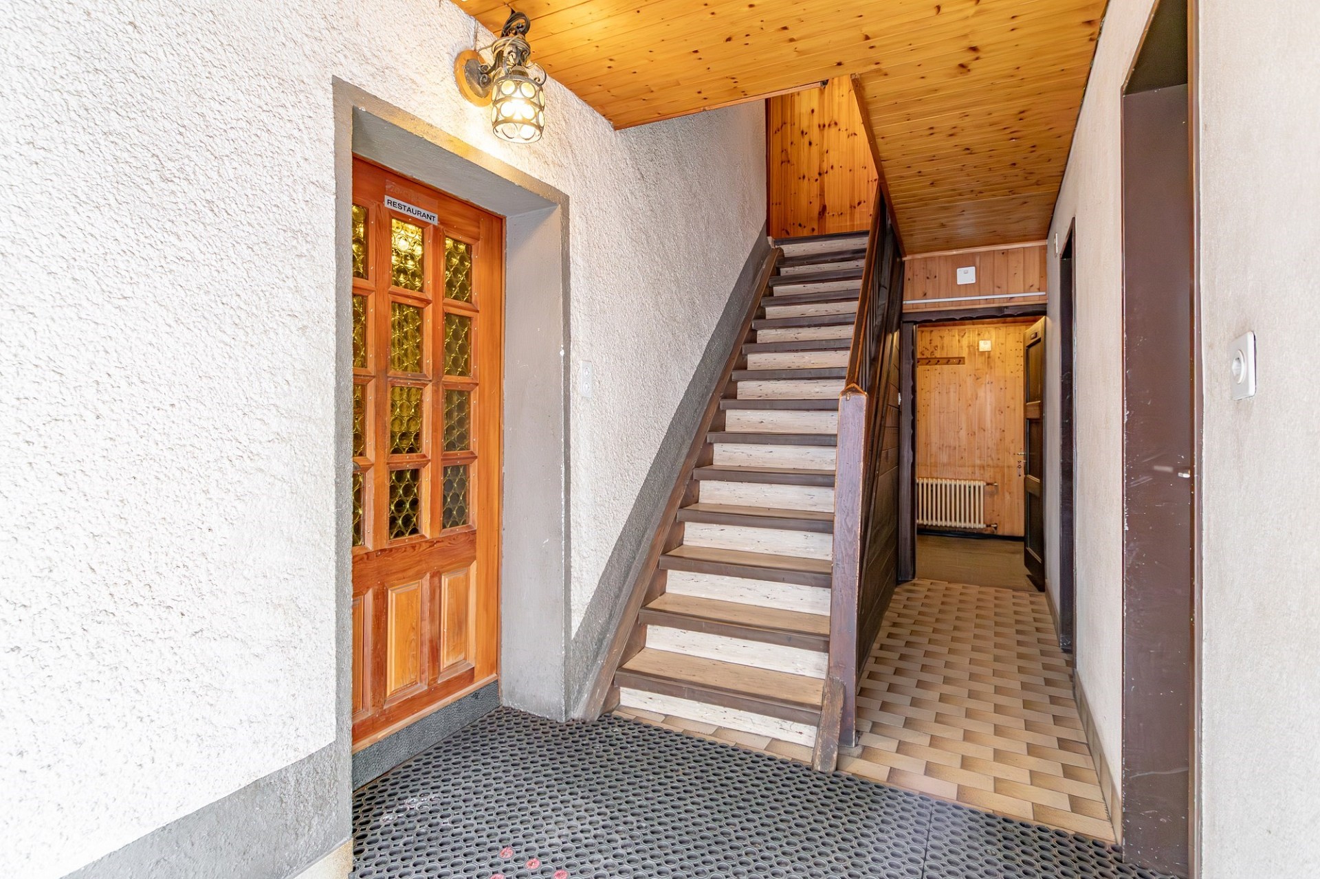 Treppenhaus mit Holzdecke und Eingangsbereich
