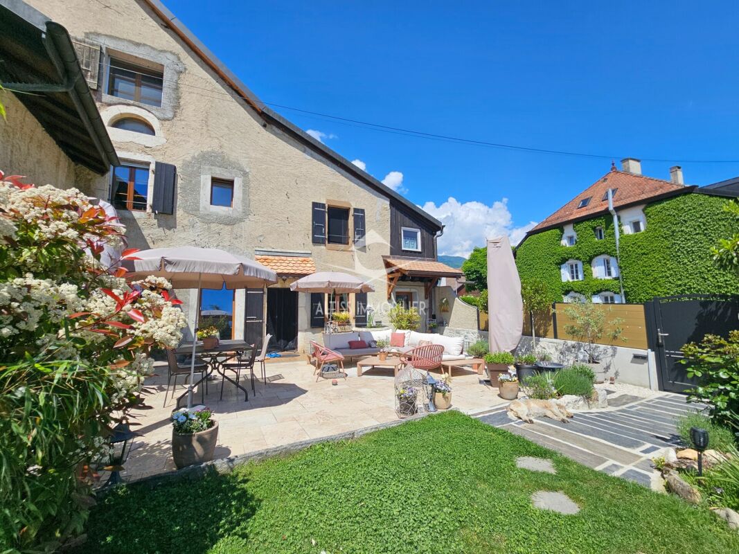 Sonniger Innenhof mit historischer Fassade und Gartenmöbeln