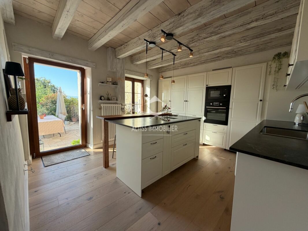 Helle Landhausküche mit Kochinsel und Terrassenzugang