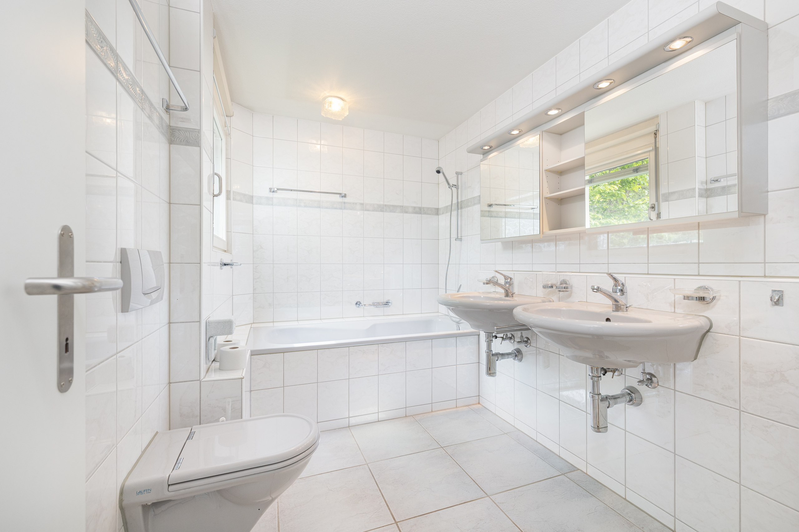 Helles weißes Badezimmer mit Doppelwaschbecken