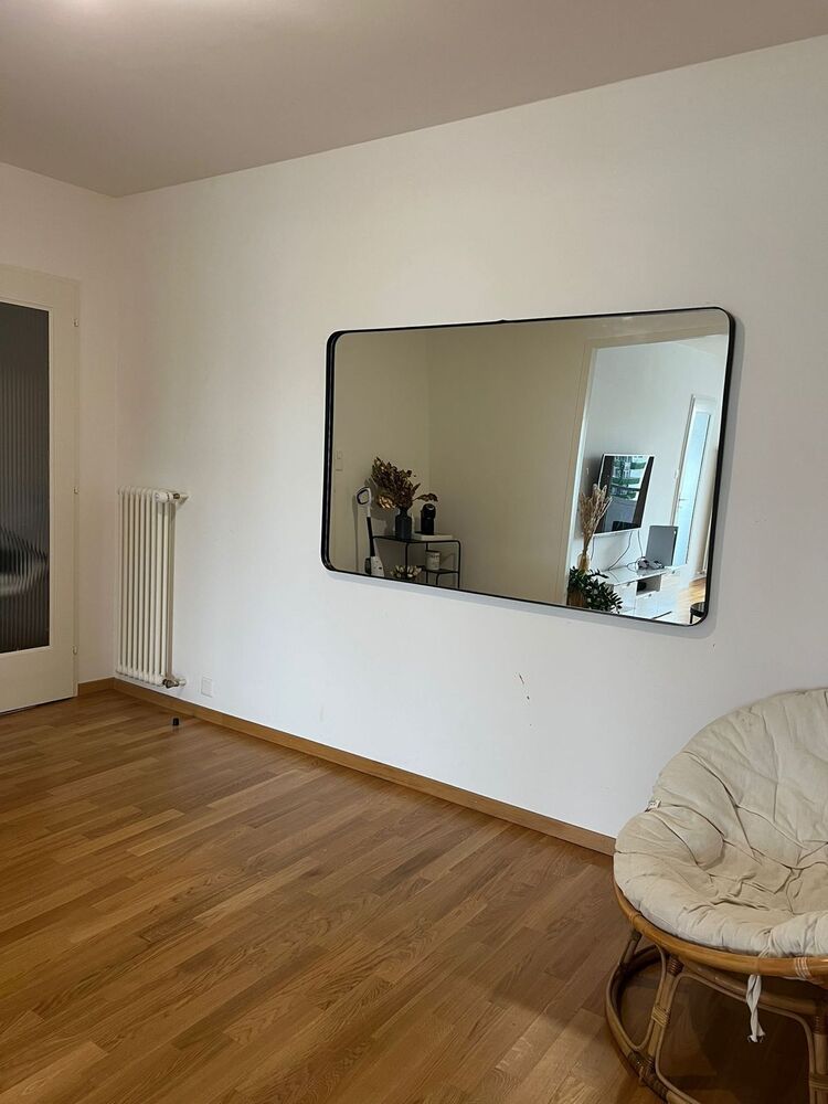 Leerer Wohnraum mit Spiegel und Holzfußboden