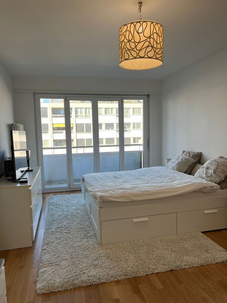 Helles Schlafzimmer mit Balkon und weißer Möblierung