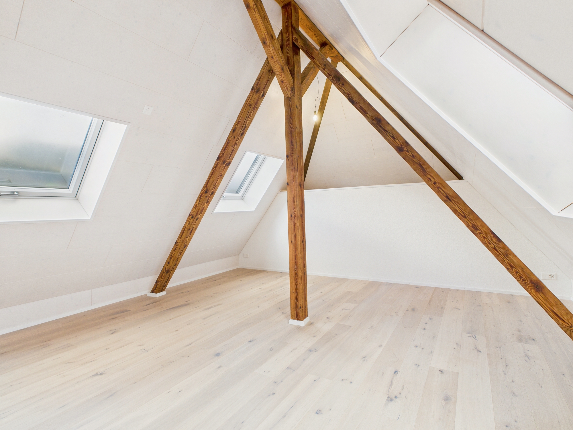 Dachgeschossraum mit sichtbaren Holzbalken