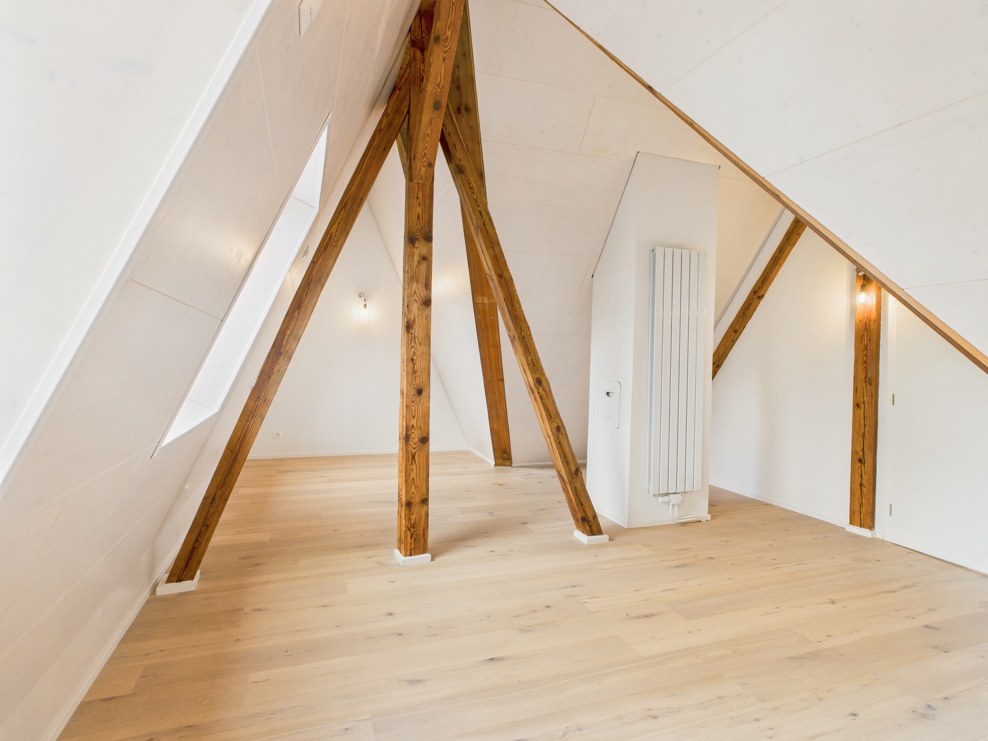 Dachgeschossraum mit sichtbaren Holzbalken