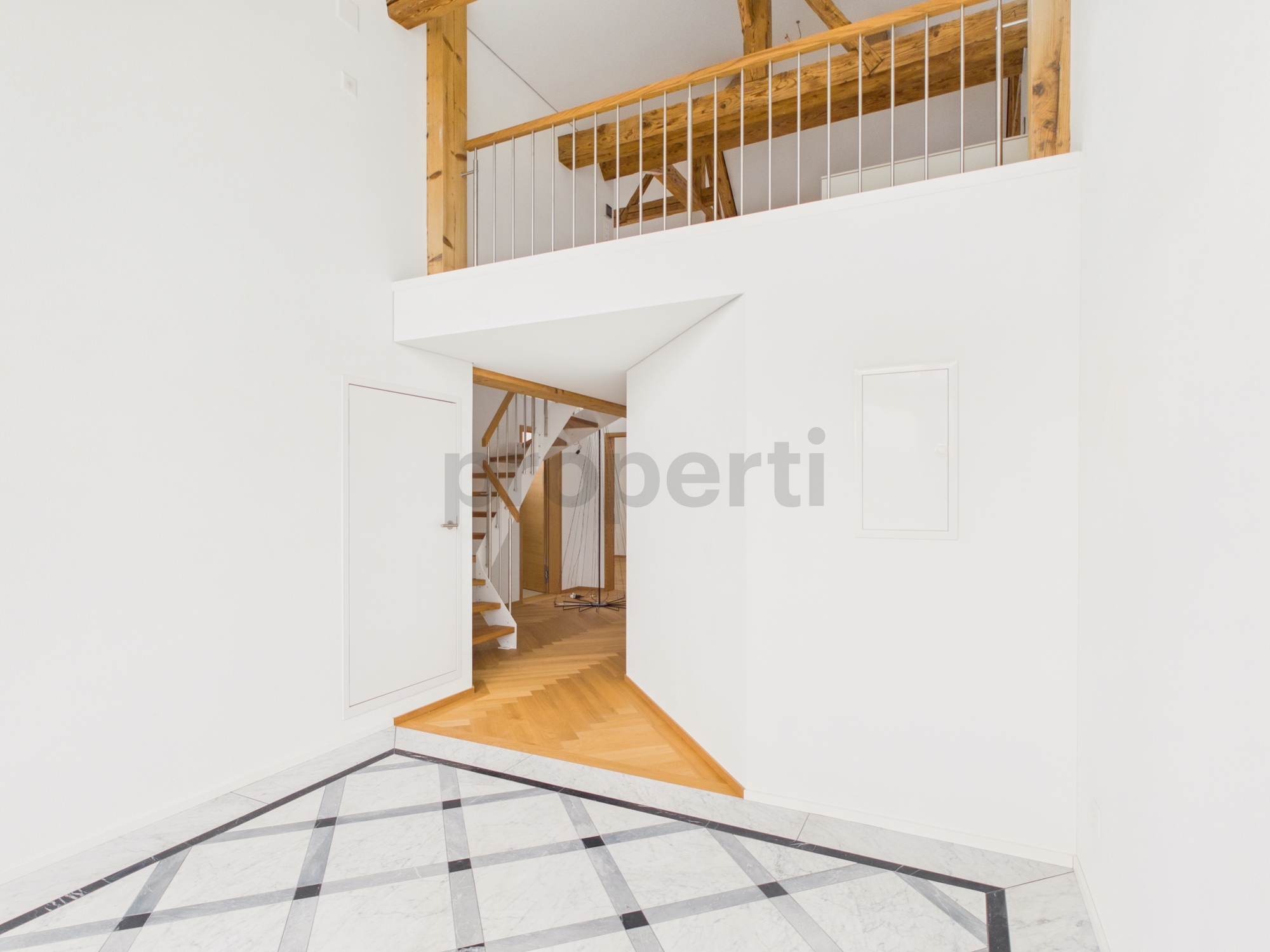 Heller Eingangsbereich mit Galerie und Treppe