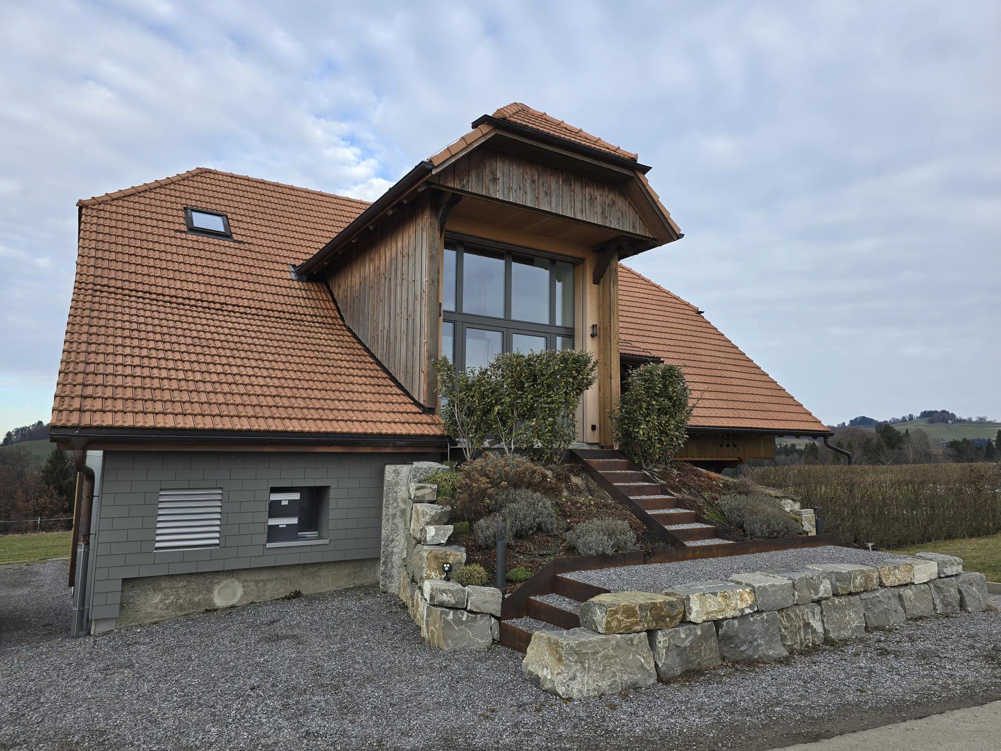 Ländliches Haus mit Ziegeldach und Holzfassade