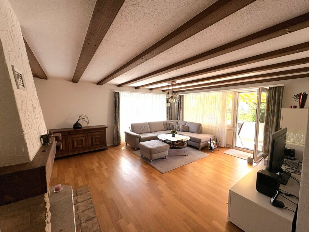 Wohnzimmer mit sichtbaren Holzbalken und Kamin