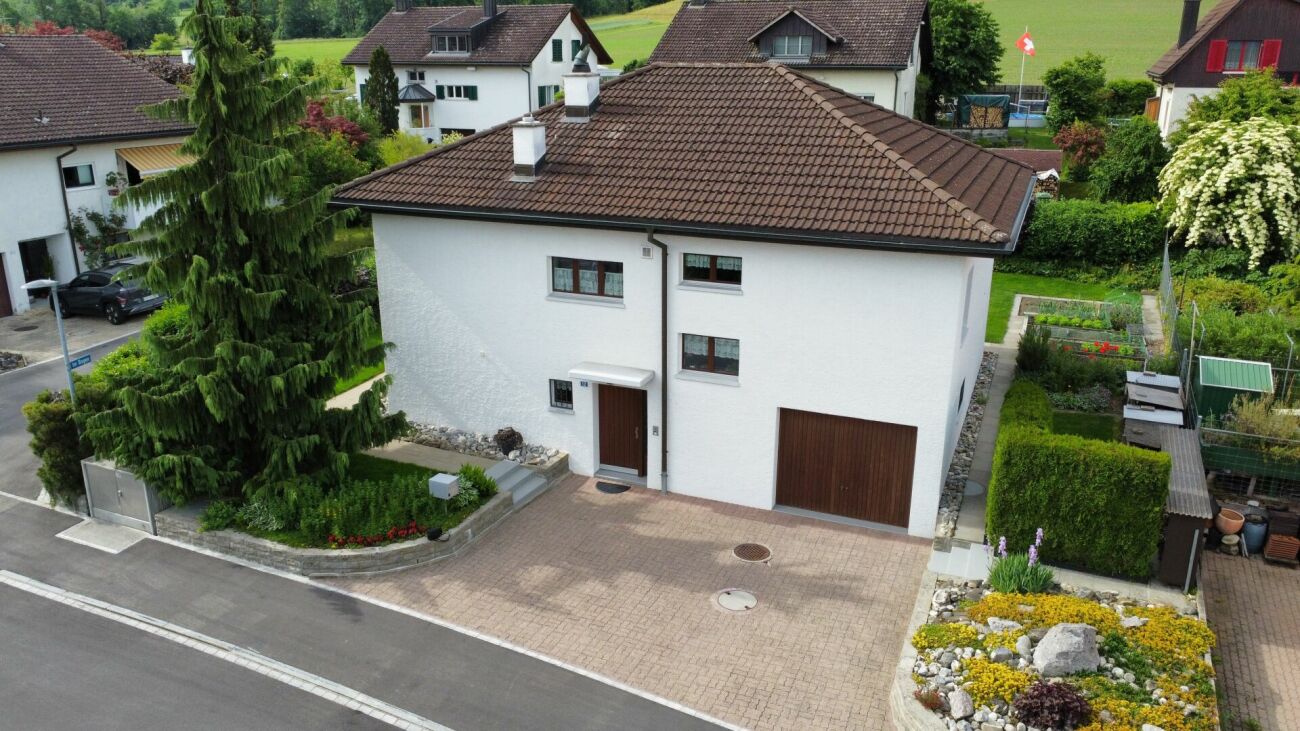 Luftaufnahme eines freistehenden Einfamilienhauses mit Garten und Einfahrt