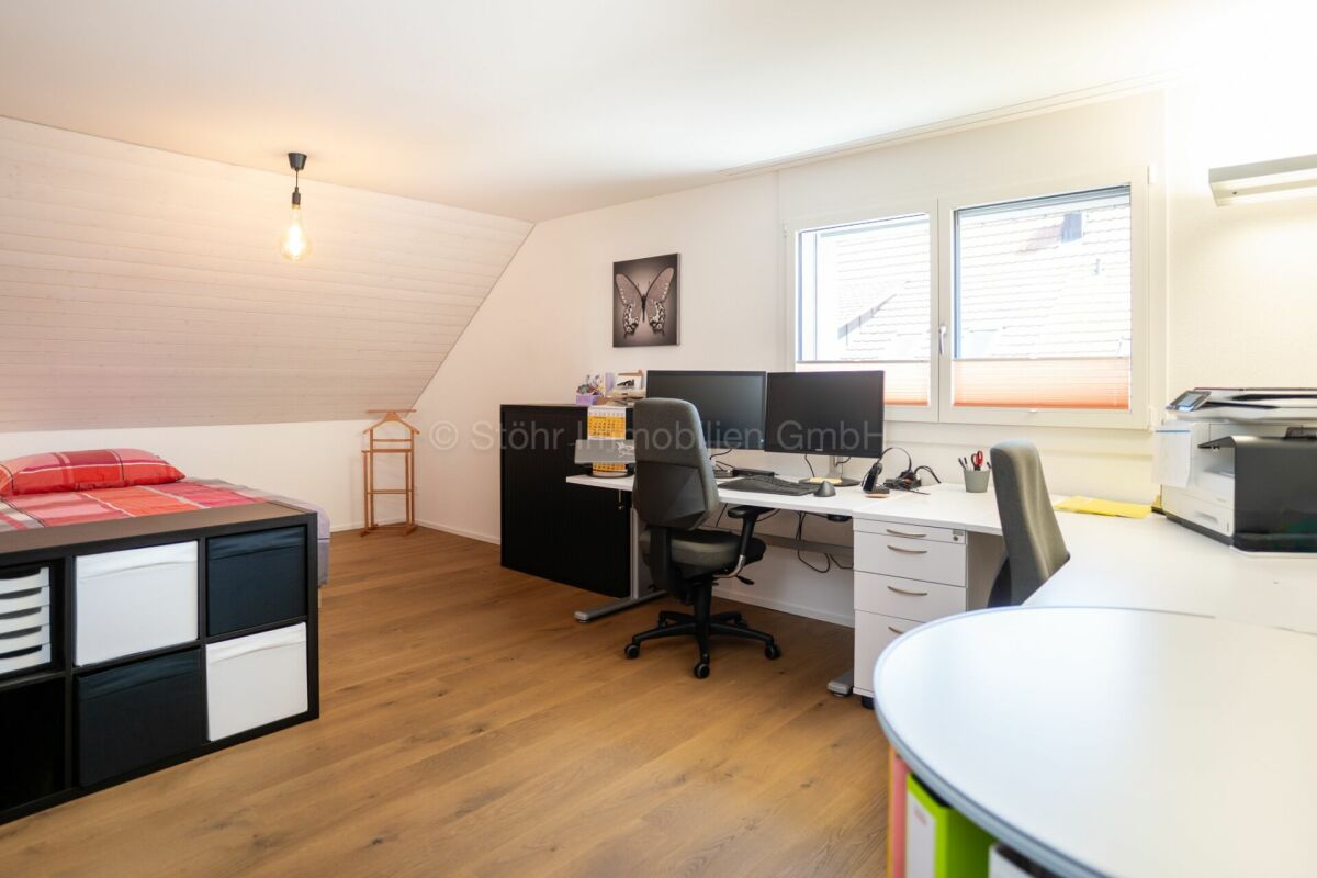 Dachzimmer mit Arbeitsbereich und Bett