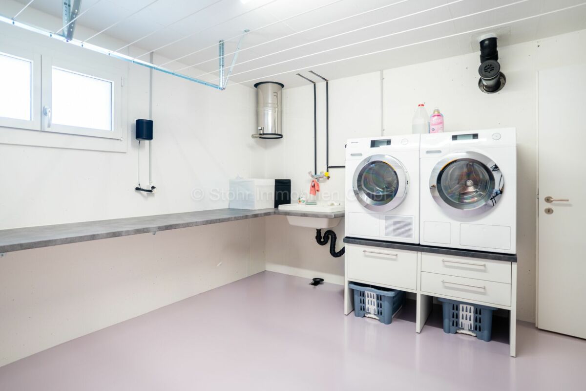 Hauswirtschaftsraum mit Waschmaschinen und Arbeitsfläche