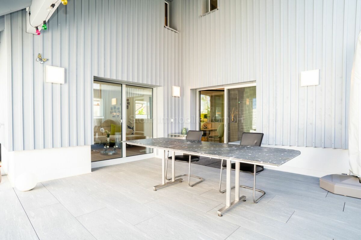 Überdachte Terrasse mit großem Esstisch