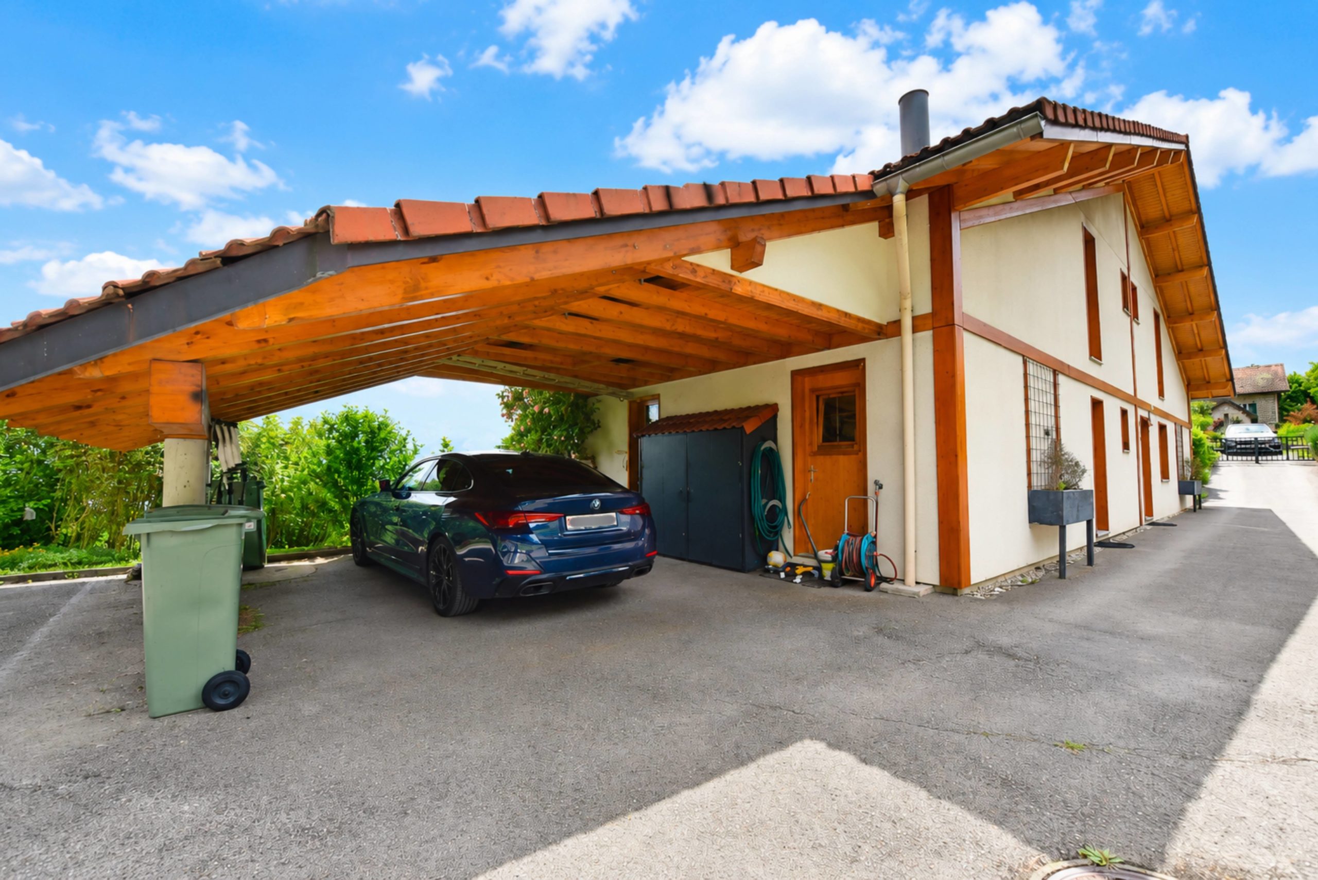 Carport mit Wohnhaus und Zufahrt