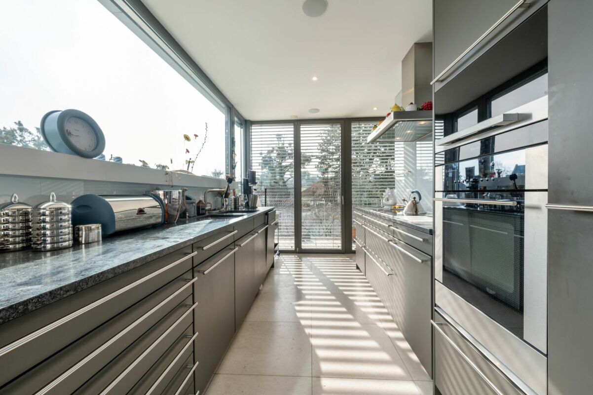 Moderne schmale Küche mit großen Fensterflächen