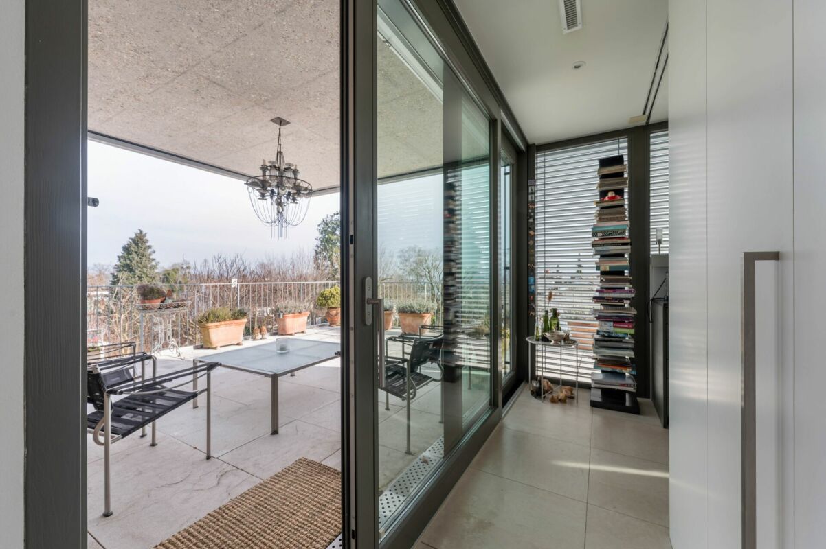 Überdachter Balkon mit Schiebetür und Regalen