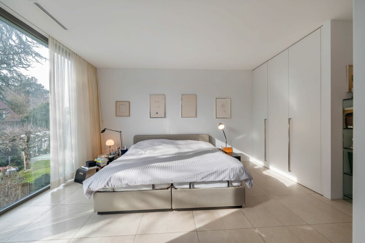 Helles Schlafzimmer mit großer Fensterfront und Einbauschrank