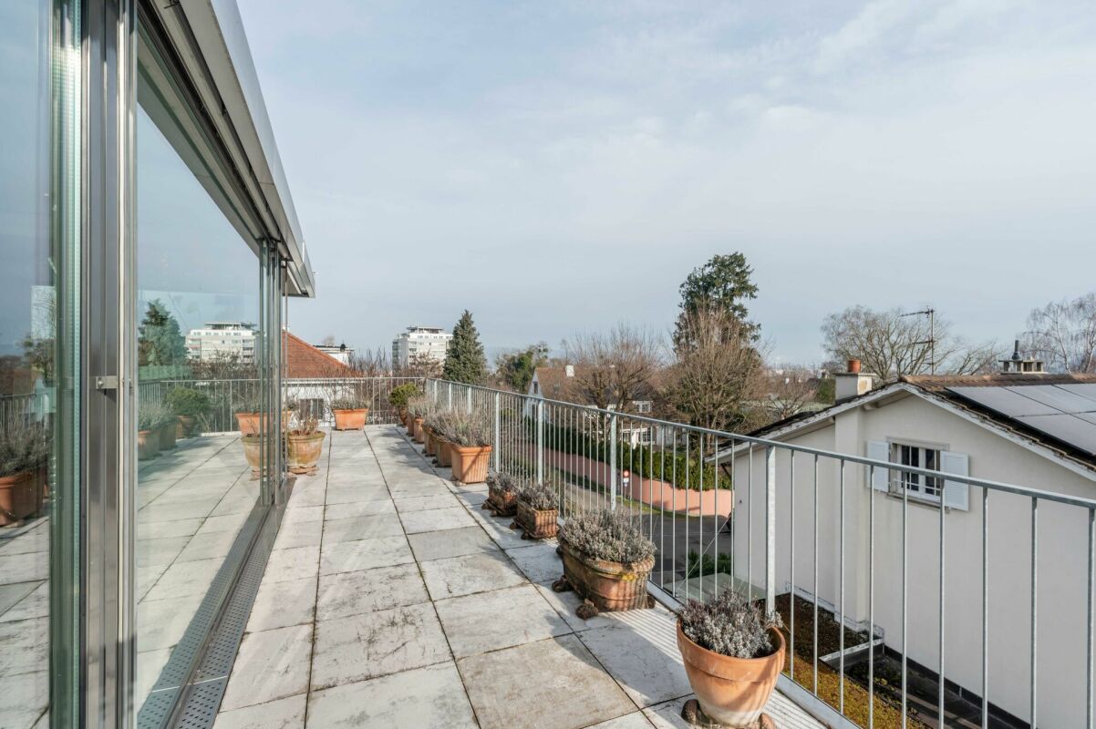 Große Dachterrasse mit Glasfront und Pflanzkübeln