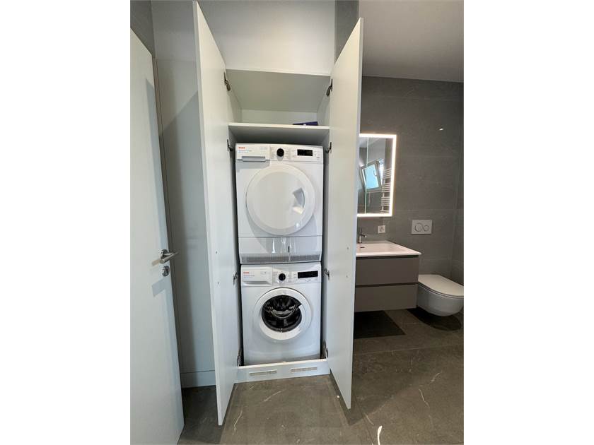 Badezimmer mit Waschmaschinen-Schrank