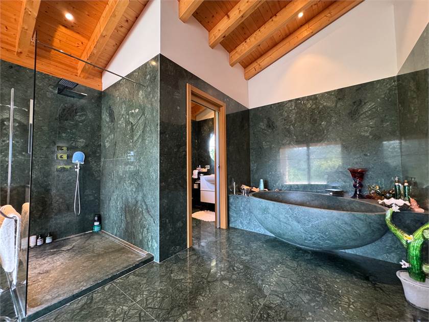Luxuriöses Badezimmer mit Naturstein und Holzbalkendecke