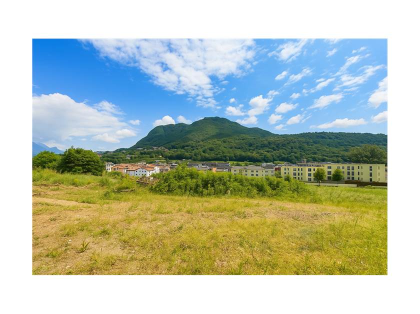 Landschaft mit Bergen und Wohnbebauung