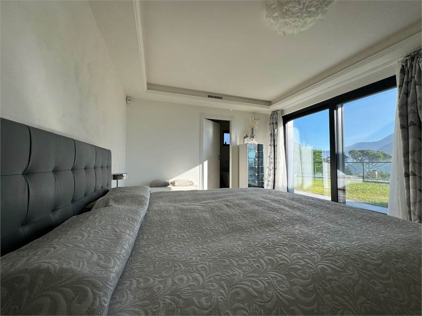Schlafzimmer mit Panoramafenster und Bett