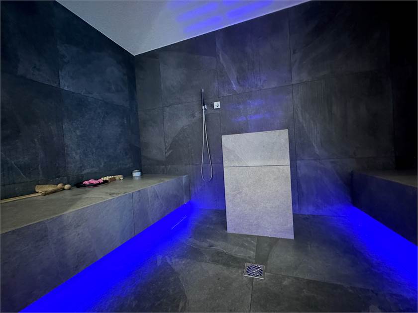 Moderne dunkle Wellness-Dusche mit blauer LED-Beleuchtung