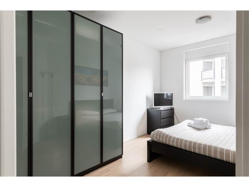 Helles Schlafzimmer mit Schrankwand und Fenster