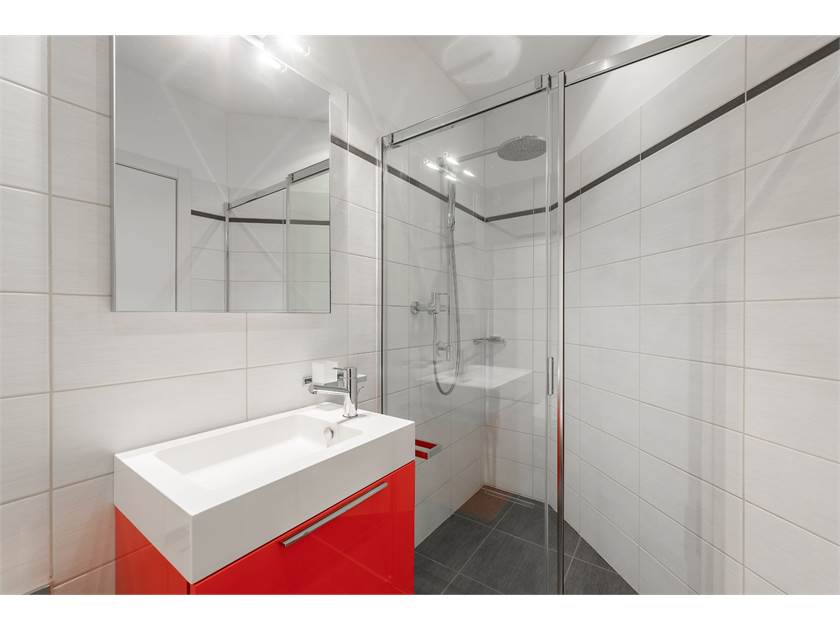 Modernes Badezimmer mit Dusche und rotem Waschtischunterschrank