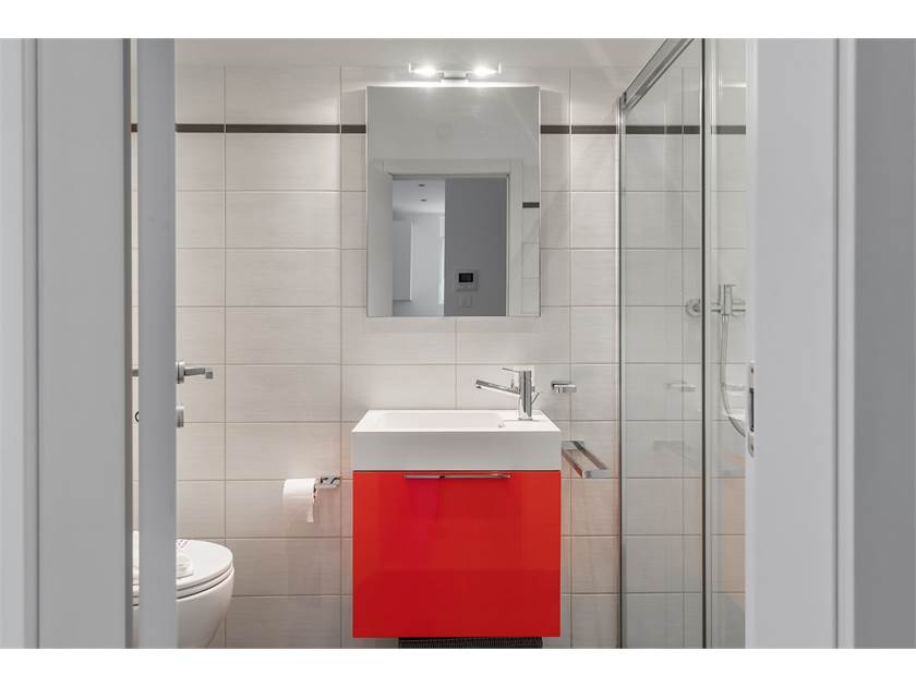 Modernes Badezimmer mit rotem Waschtischunterschrank
