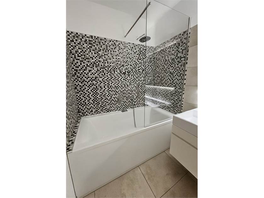 Modernes Badezimmer mit Badewanne und Mosaikfliesen