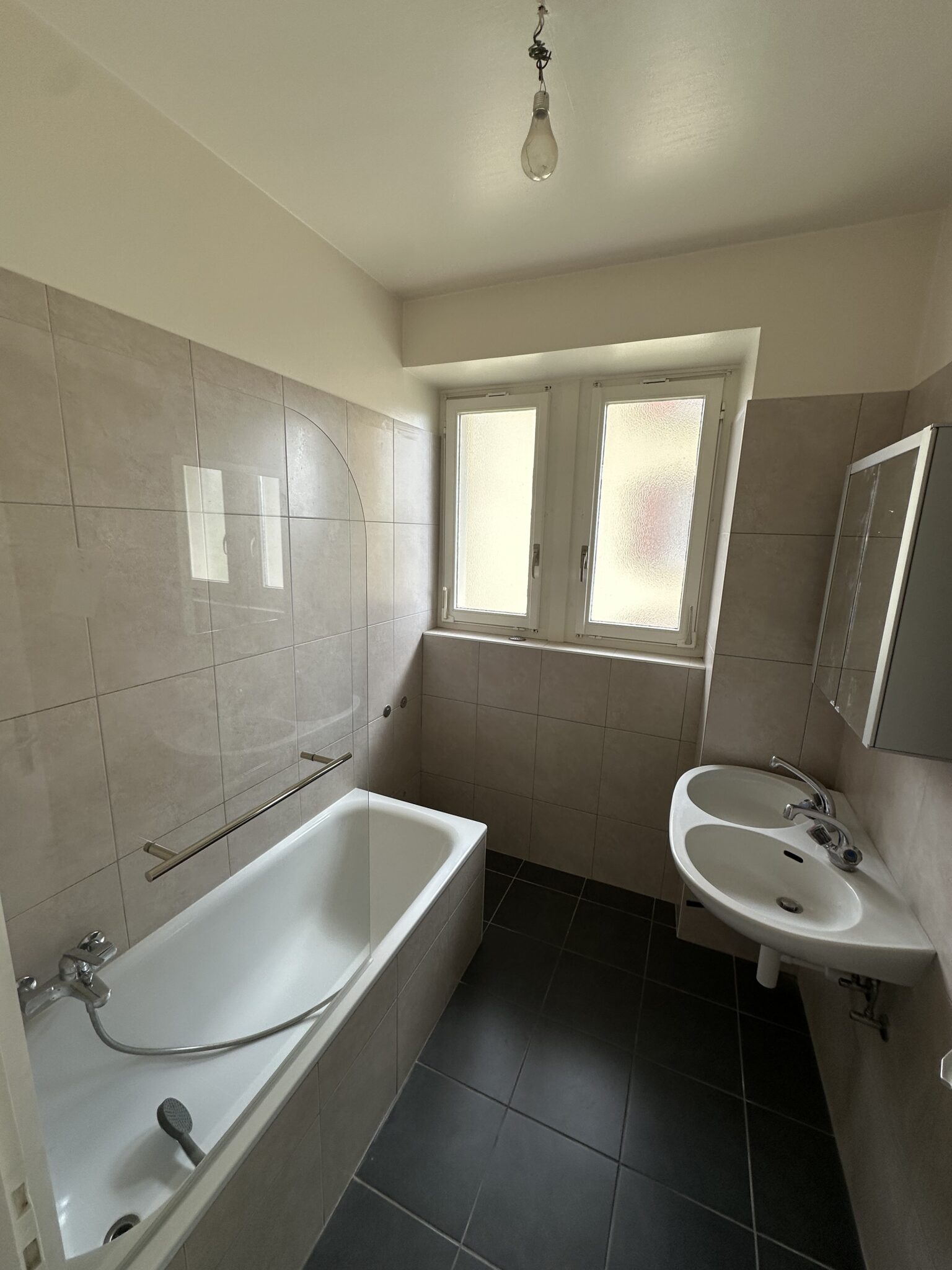 Badezimmer mit Badewanne und Doppelwaschbecken