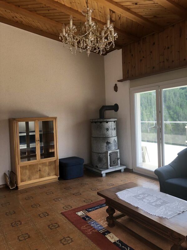 Wohnzimmer mit Holzdecke und Balkonzugang