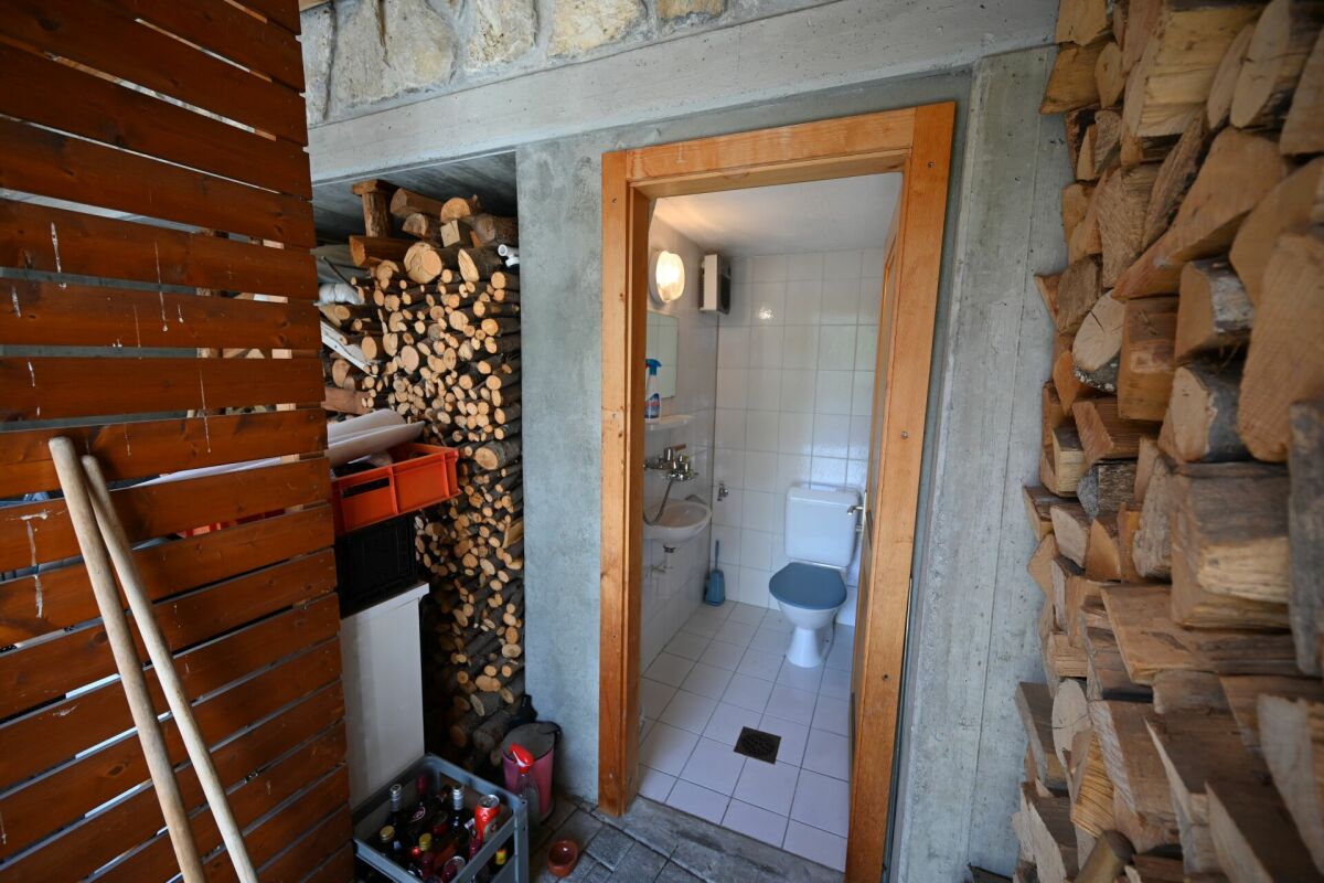 Rustikaler Außenbereich mit Zugang zu einem kleinen WC