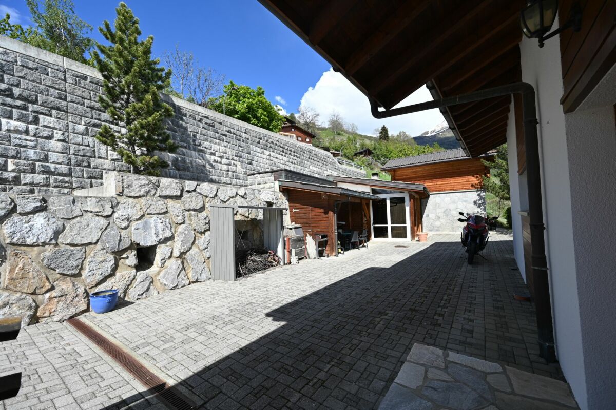 Blick auf einen gepflasterten Innenhof mit Natursteinmauern